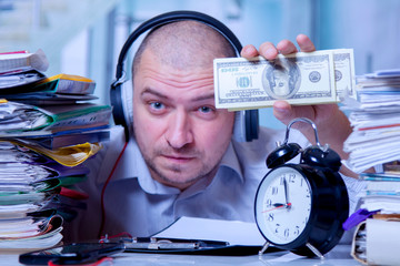 Best motivation is money. Happy businessman working in the office for the money. Selective focus on US Dollar bills.
