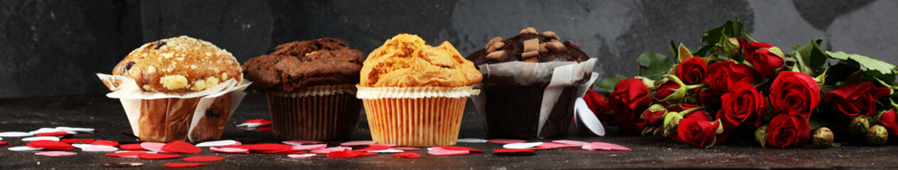 chocolate muffins, blueberry muffin and nut muffins on dark background for Valentine's day....
