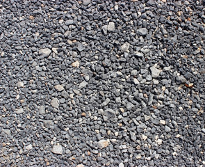 Crushed old asphalt pavement. Small gray-black pebbles.