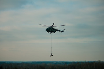 military army helicopter transporting an artillery piece.