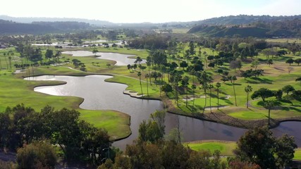 Aerial drone footage over green golf courses in the community of Del Mar, San Diego, California.  