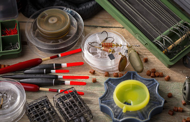 Fishing rods and spinnings in the composition with accessories for fishing on the old background on the table