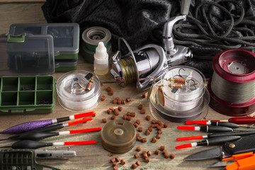 Fishing rods and spinnings in the composition with accessories for fishing on the old background on...