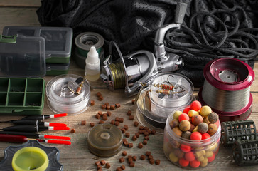 Fishing rods and spinnings in the composition with accessories for fishing on the old background on the table