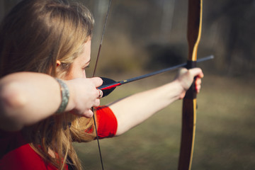Girls dressed as medieval teaching archery at the field - obrazy, fototapety, plakaty