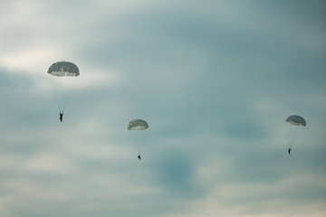 Army paratroopers jumping at air war action.