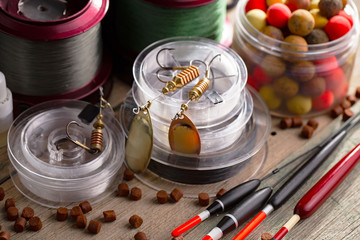 Fishing rods and spinnings in the composition with accessories for fishing on the old background on...