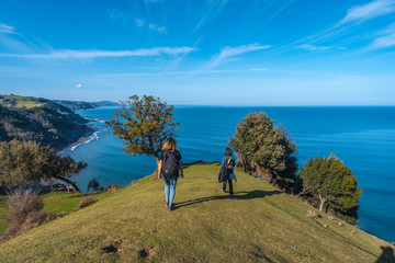 Deba, Gipuzkoa / Spain »; January 26, 2020: Two young people walking along the beautiful coast...