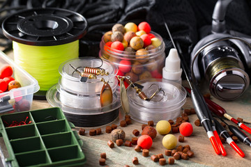 Fishing rods and spinnings in the composition with accessories for fishing on the old background on the table