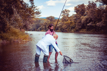 Weekend fishing. Real happiness. Handsome man and father relax. Man fisherman catches a fish. Bearded man and elegant businessman fishing together. Just do that only. Legend has retired.