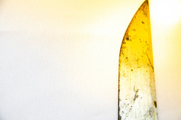Old large rusty kitchen knife on a white background and in a hand. Blade, handle, parts of a knife in macro. Flare flare. CopySpace