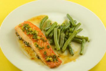 Healthy salmon fish fillet with sauce and green beans lunch or dinner meal on white plate