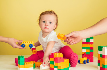 Caucasian little girl, children isolated on yellow studio background. Portrait of cute and adorable kid, baby playing and looks serious. Concept of childhood, family, happiness, new life, education.