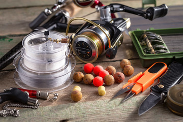 Fishing rods and spinnings in the composition with accessories for fishing on the old background on...