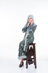 Fototapeta premium Beautiful female model in various poses wearing modern kebaya and hijab, a modern urban lifestyle apparel for Muslim women isolated on white background. Beauty and hijab fashion concept. Full length.