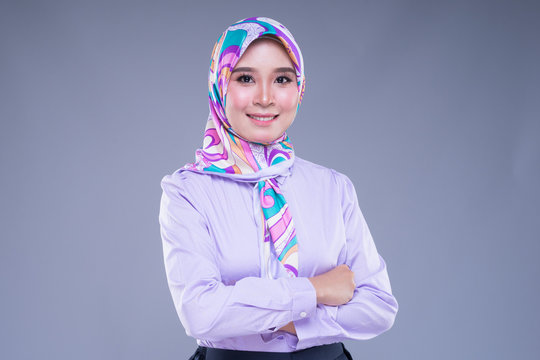Half length portrait of an attractive Muslim woman wearing business attire and hijab with mixed poses and gestures isolated on grey background. For image cut-out for technology, business or finance.