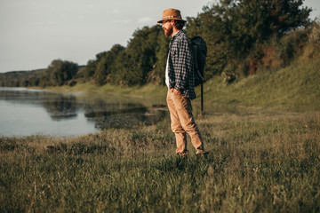 Male traveler standing by lake admiring view