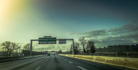 High speed highway with signage against dark sky