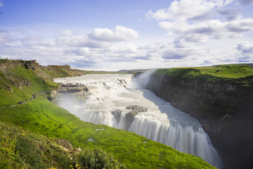 a picture of the impressive and gigantic waterfall gulfoss in iceland, taken during the blue hour on a cloudy day.