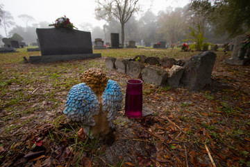 Blue wings on a child angel statue in a cemetery
