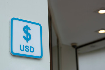 Dollar signs. Written in blue on white signboard.