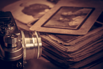 A camera next to an old photo album on the table.