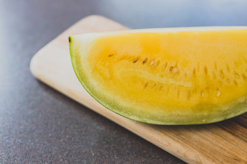 yellow watermelon on cutting board on kitchen top