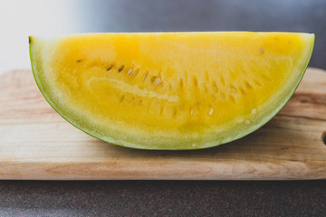 yellow watermelon on cutting board on kitchen top