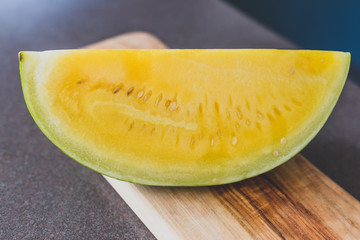 yellow watermelon on cutting board on kitchen top