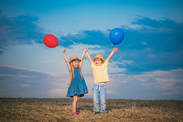Happy children playing in summer. Little boy and girl enjoy life and nature. Little girl and boy enjoy walk. Happy girl and boy in the field. Positive little girl and boy.