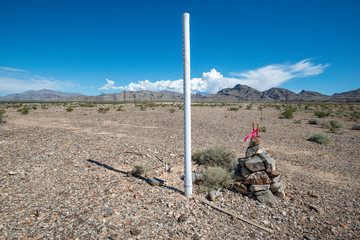 USA, Nevada, Clark County, Las Vegas Valley. A white PVC marker and rock cairn established at a...
