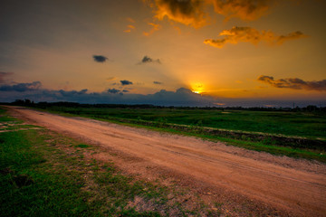 Blurred twilight evening background on rice paddies, with high voltage electricity towers passing...