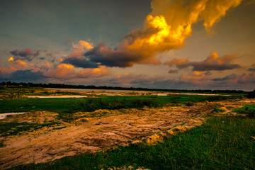 Blurred twilight evening background on rice paddies, with high voltage electricity towers passing...