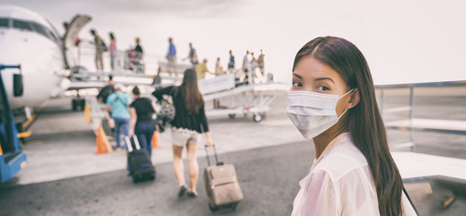 COVID-19 Travel Airport Asian woman tourist boarding plane leaving on vacation wearing face mask....