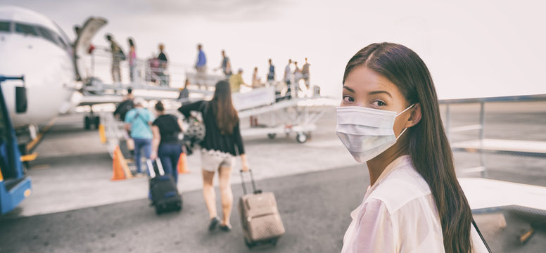 COVID-19 Travel Airport Asian woman tourist boarding plane leaving on vacation wearing face mask. Coronavirus corona virus pandemic banner panoramic. Social distance, travel ban restriction, tourism.