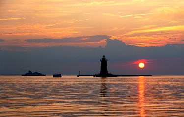 Silhouette of the lighthouse and boats during the sunset at Cape Henlopen State Park, Lewes, Delaware, U.S.A © Khairil