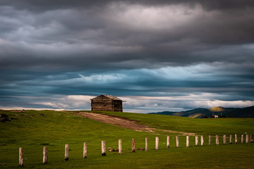 Storm clouds over log cabin