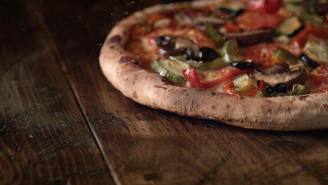 Camera follows a whole pizza with pepperoni being served. Slow Motion. 