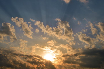 The light of the rising sun in the morning surrounded by clouds.
