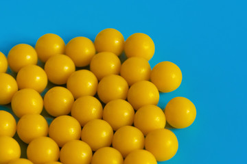 Yellow vitamins on a blue background. Vitamin complex against the virus. Multivitamins to enhance health and immunity. Medical concept.