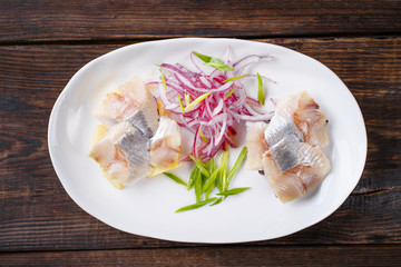 herring and potato appetizer with red onion. fish snack, holiday salad. nourishing and tasty food.