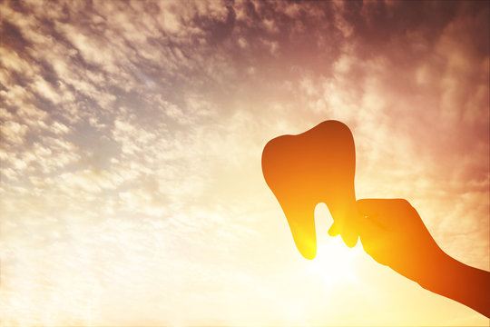 Silhouette hands holding dentistry symbol, Tooth care concept.