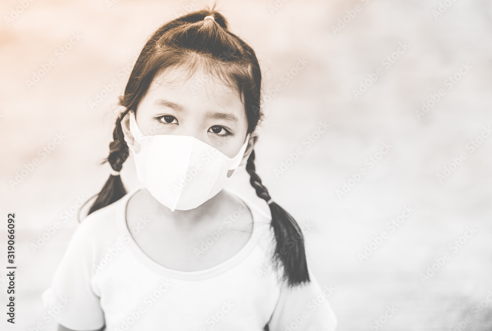 Wall mural Coronavirus and Air pollution pm2.5 concept.Little chinese girl wearing mask for protect pm2.5 and pointing finger in mask for corona virus protection.Wuhan coronavirus and epidemic virus symptoms.