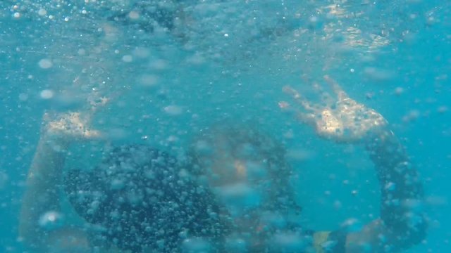 Boy in T-shirt tries to swim out of the pool