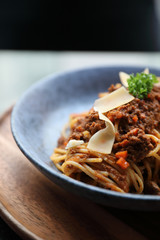 spaghetti Bolognese with minced beef and tomato sauce garnished with parmesan cheese and basil , Italian food