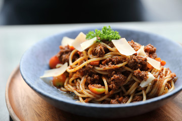 spaghetti Bolognese with minced beef and tomato sauce garnished with parmesan cheese and basil , Italian food