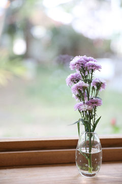 purple flower in jar on wood background in japanese restuarant