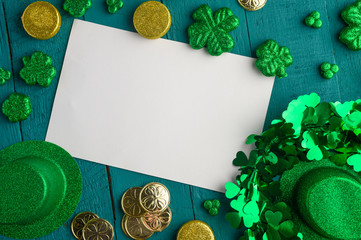 Flat lay, St. Patrick's Day, white card for congratulation. March 17, on a green background with...
