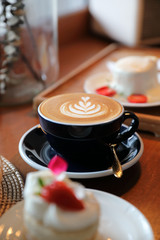 Coffee and strawberry cream cake on wooden table