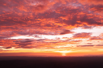 Fototapeta na wymiar Beautiful red vibrant burning sunset sky with clouds